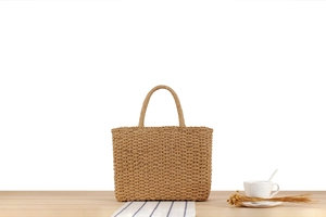 Vue détaillée d'un sac de plage en paille tressé à la main sur une table chic