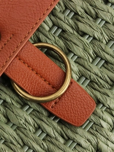 Green woven straw bag with brown leather strap and vintage metal ring detail