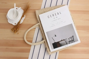 Détail d'un sac cabas tissé beige avec texture fine et poignée ronde épaisse