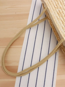 Handmade woven straw beach shoulder bag for women on a summer vacation background