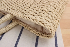 Gros plan sur la texture tissée beige et la doublure en tissu du grand sac de plage