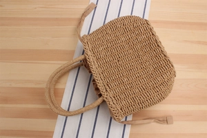 Detail of woven straw handbag featuring natural plant fibers and drawstring lining