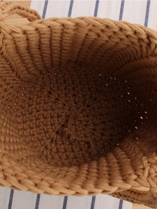 Top-down view of a handmade brown cotton woven bucket bag with detailed knit texture