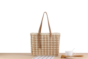 Close-up of checkered woven tote bag texture with brown leather handles and buckle