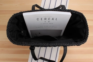 Vertical top view of large straw tote bag showing spacious black fabric interior and pockets