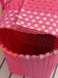 Handwoven colorful plastic beach basket bag with peach pink and orange weave details