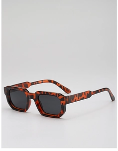 Détail de lunettes de soleil carrées en écaille avec monture épaisse et verres foncés