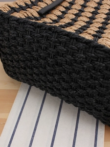 Minimalist woven straw tote bag with black leather straps and checkered pattern texture
