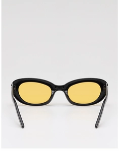 Detail view showing black retro oval frame with vibrant yellow lenses and metal hinges