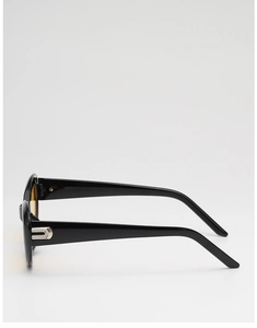 Detail of retro oval sunglasses showing black frame, yellow lens and silver metal temple hinge