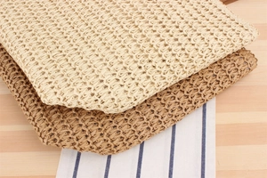 Détail du motif au crochet ajouré en losange sur des sacs en corde de papier crème et brun