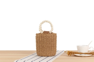 Detail der geflochtenen Strohtasche mit Holzperlengriffen und Lederbesatz am Rand