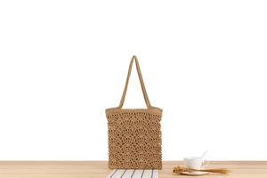 Close-up of handmade crochet tote bag with intricate shell pattern and natural straw texture