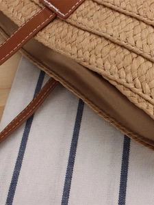 Handwoven straw tote bag with brown leather straps and summer vacation style design