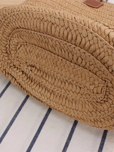 Straw woven tote bag with durable oval base and detailed stitching for beach vacation