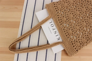 Detailed close-up of a khaki crochet woven tote bag on a rustic minimalist background