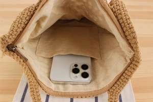Top view of hand-woven shoulder bag showing interior space with a smartphone in the inner pocket