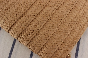 Macro shot of brown woven texture and gold metal ring fastener on the crossbody envelope bag