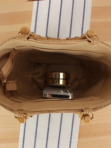 Handwoven straw tote with bamboo handles and internal zipper pocket for essentials
