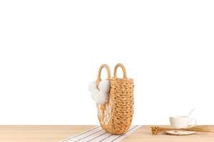 Détail du sac à main en paille avec broderie Bride et décorations de pompons blancs