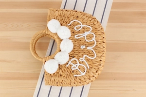 Détail de la broderie Bride et pompons blancs sur le sac de plage tissé à la main