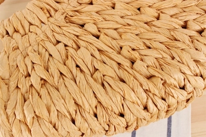 Gros plan sur la texture en paille tressée main d'un sac cabas beige pour la plage