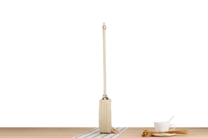 Dettaglio della borsa rotonda in paglia beige intrecciata con lunghe nappe e tracolla
