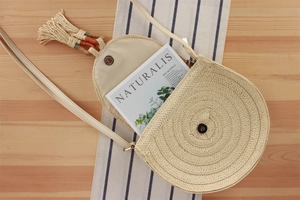 Dettaglio della borsa rotonda in corda intrecciata beige con nappa e chiusura magnetica