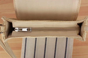 Dettaglio della borsa in corda di carta con chiusura a zip e fodera in tessuto beige