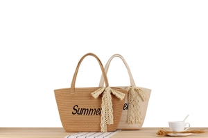 Détail de sacs de plage tissés en marron et beige avec nœuds en dentelle et texte Summer