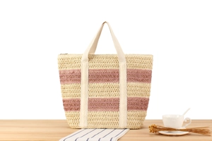 Close-up of beige paper rope tote with pink stripes and wide fabric handles