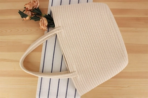 Détail d'un cabas en corde de coton beige avec une texture fine et des poignées solides