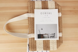 Top view of two-tone woven paper rope tote bag with striped pattern and zipper detail