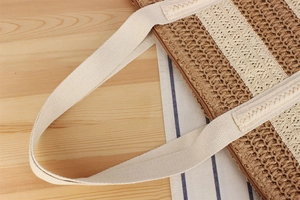 Close-up of dual-tone woven paper rope texture with canvas handle and zipper detail