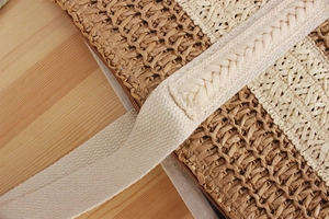 Detail of two-tone paper rope woven tote bag with durable cream fabric handles