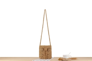 Close-up of handmade woven hollow flower crossbody bag with intricate crochet pattern detail