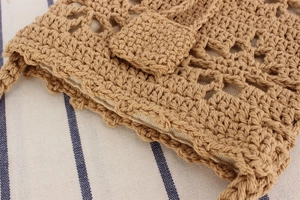 Detail of handmade cotton rope crochet bag with hollow flower pattern and inner lining