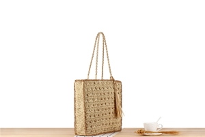 Vue détaillée du sac cabas tissé main avec motif ajouré et pompon décoratif assorti