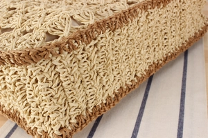 Gros plan du sac en paille tissé main beige et marron avec motifs ajourés détaillés