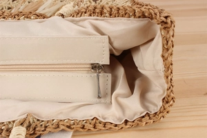 Détail du sac tissé main montrant la fermeture éclair en métal et la doublure en tissu