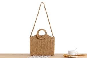 Detailed view of handmade straw woven mini tote with circular handle and shoulder strap