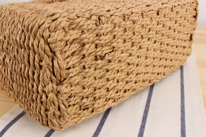 Detailed macro view of the woven texture and tight braided pattern of the handmade straw bag