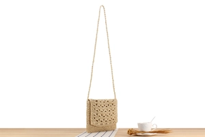 Detailed view of handmade beige paper rope crochet handbag with fan pattern texture