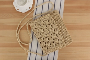 Detail of hand-crocheted paper rope crossbody bag with hollow fan pattern texture