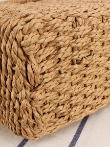 Handwoven square beach bag in natural straw with dense cross-weave and round handles