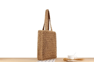 Detail view of woven tote bag with hollow texture on wooden table with coffee cup