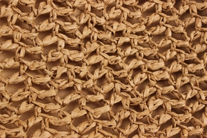 Macro detail of hand-woven raffia material showing intricate fiber texture and honeycomb pattern
