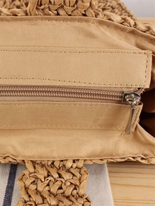 Minimalist woven straw beach bag featuring a secure metal zipper and smooth inner lining