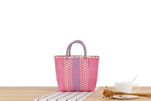 Détail du sac à main tissé en plastique aux motifs à carreaux rose, bleu et crème