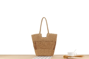 Close-up of woven paper rope tote bag with hollow mesh design and interior fabric lining